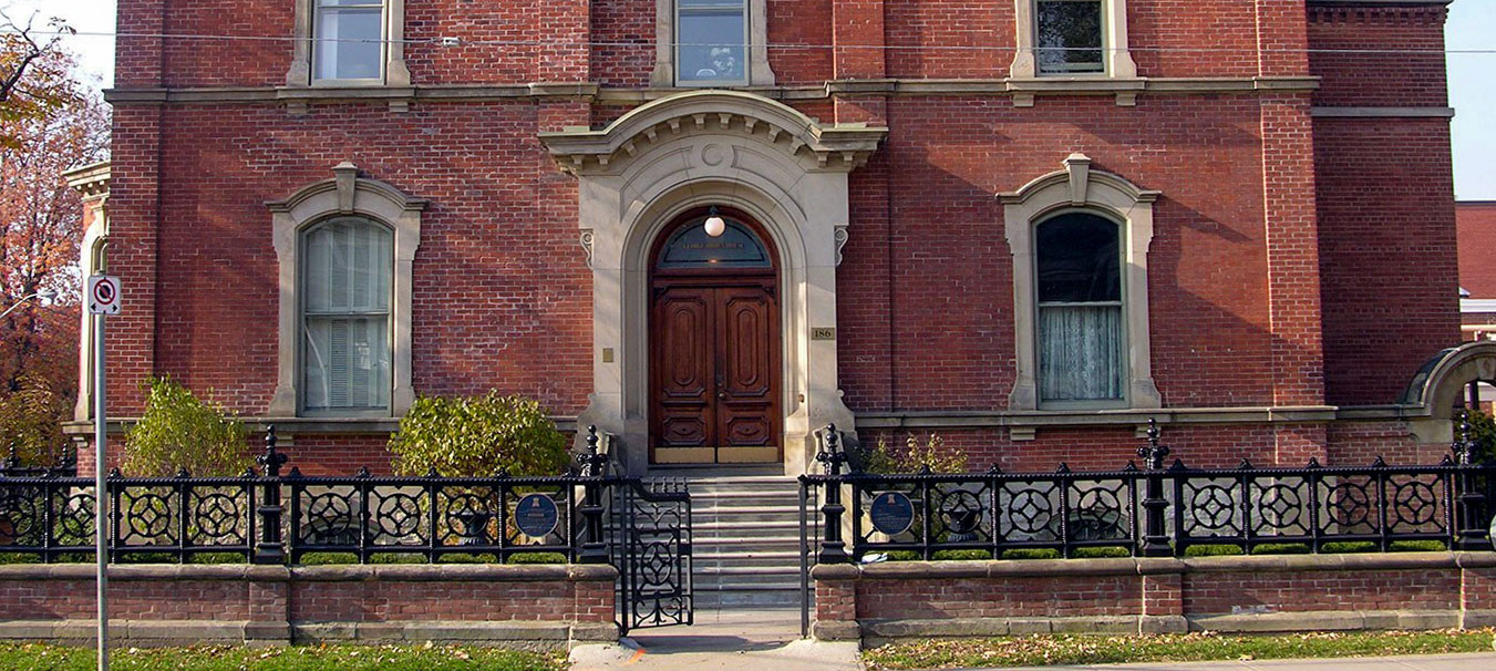 The red-brick facade of George Brown House, with its arched wooden door and wrought-iron fence, Primitive Entertainment's Toronto office.